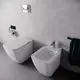 Weißes Bidet und wandhängendes WC von Ideal Standard, montiert neben einer Toilette. Hochwertige Oberflächen, einfache Bedienung und moderne Anordnung im Badezimmer.